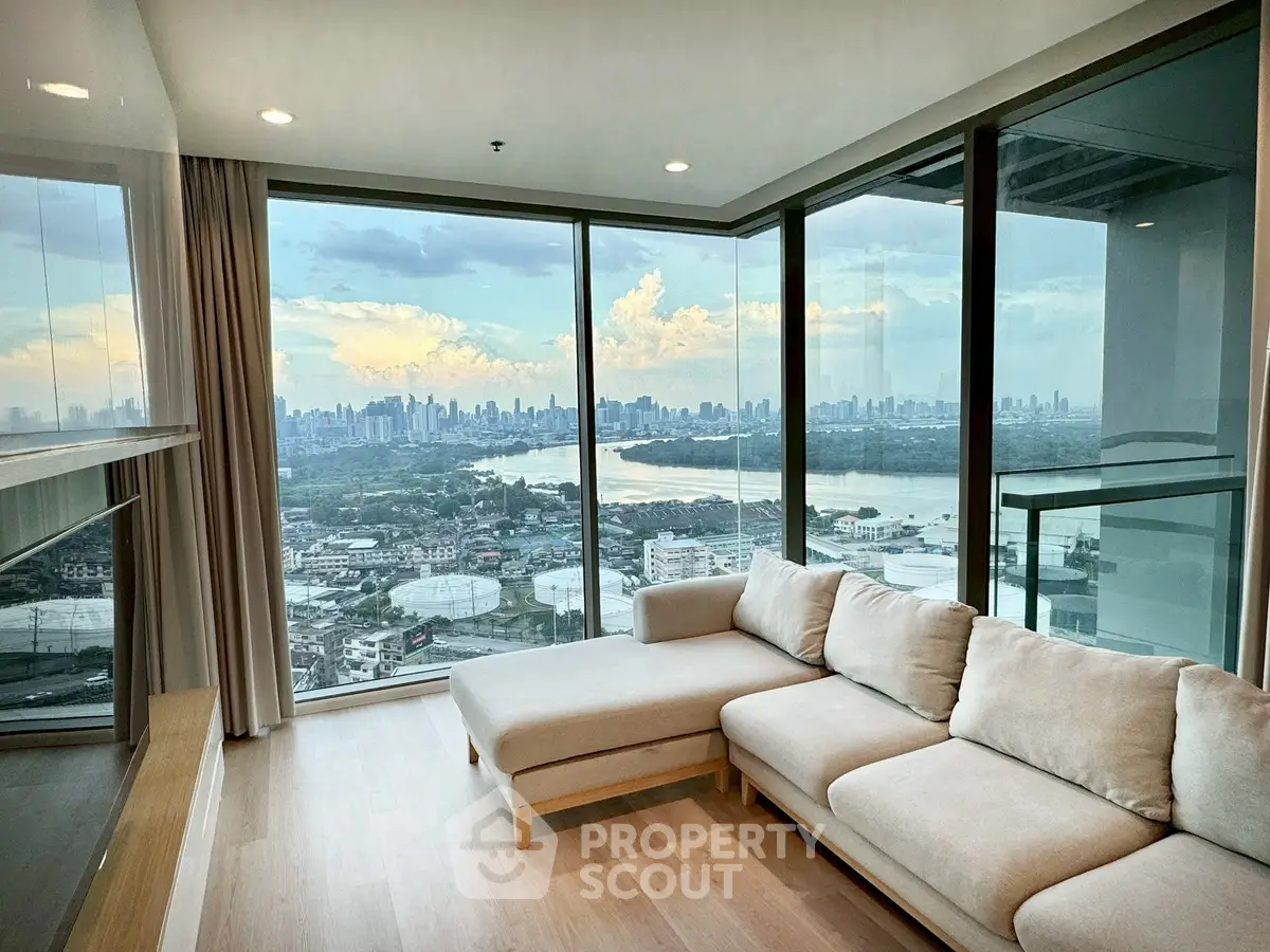 Luxurious living room with panoramic city skyline view from high-rise apartment.