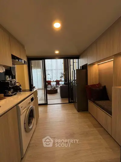 Modern kitchen with washing machine and cozy seating area in stylish apartment