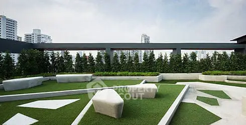 Modern rooftop garden with stylish seating and city skyline view.