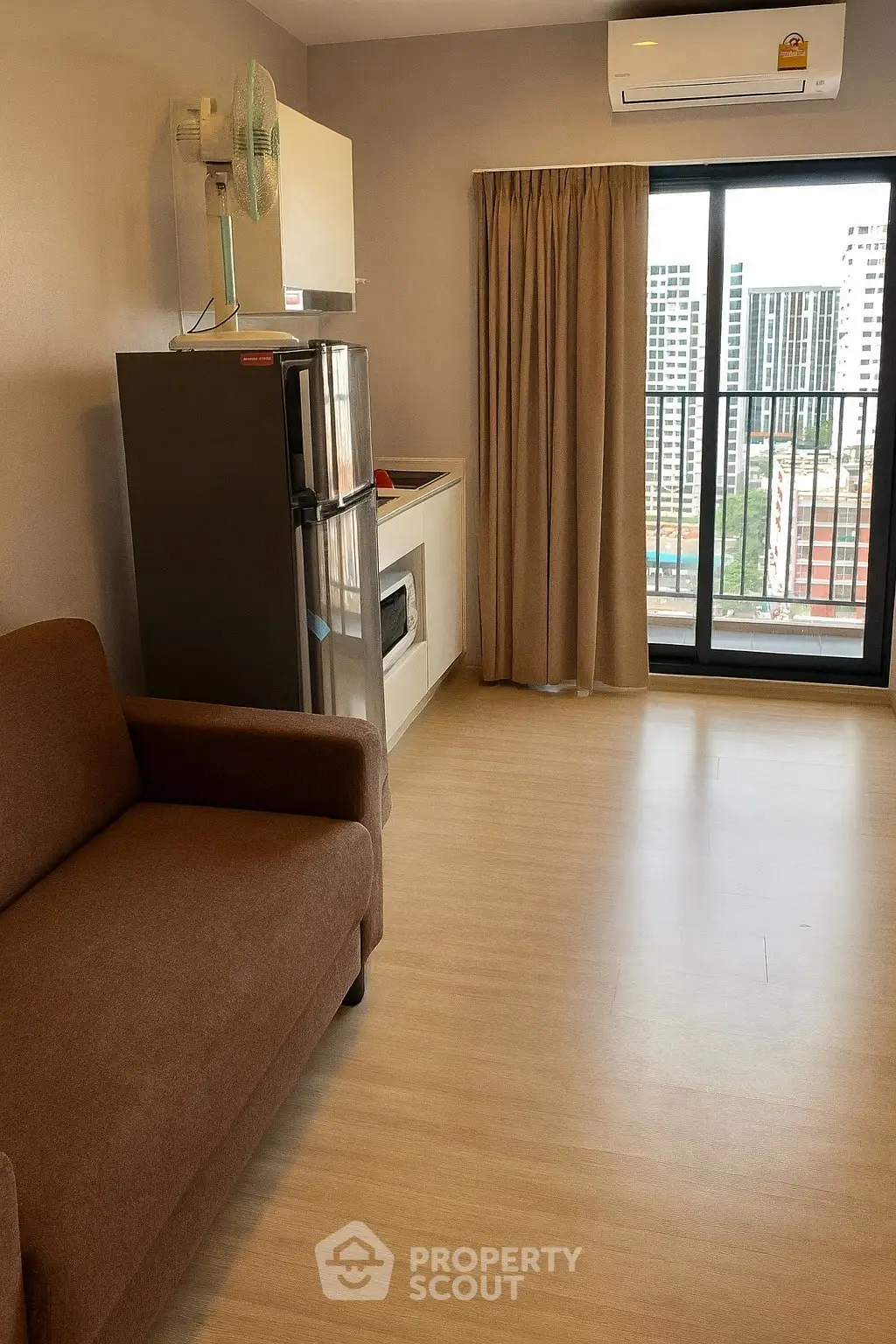 Modern apartment interior with sofa, fridge, and balcony view
