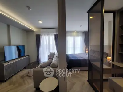 Modern open-plan living room and bedroom with stylish decor and natural light