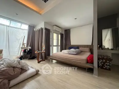 Spacious bedroom with modern decor and large windows for natural light