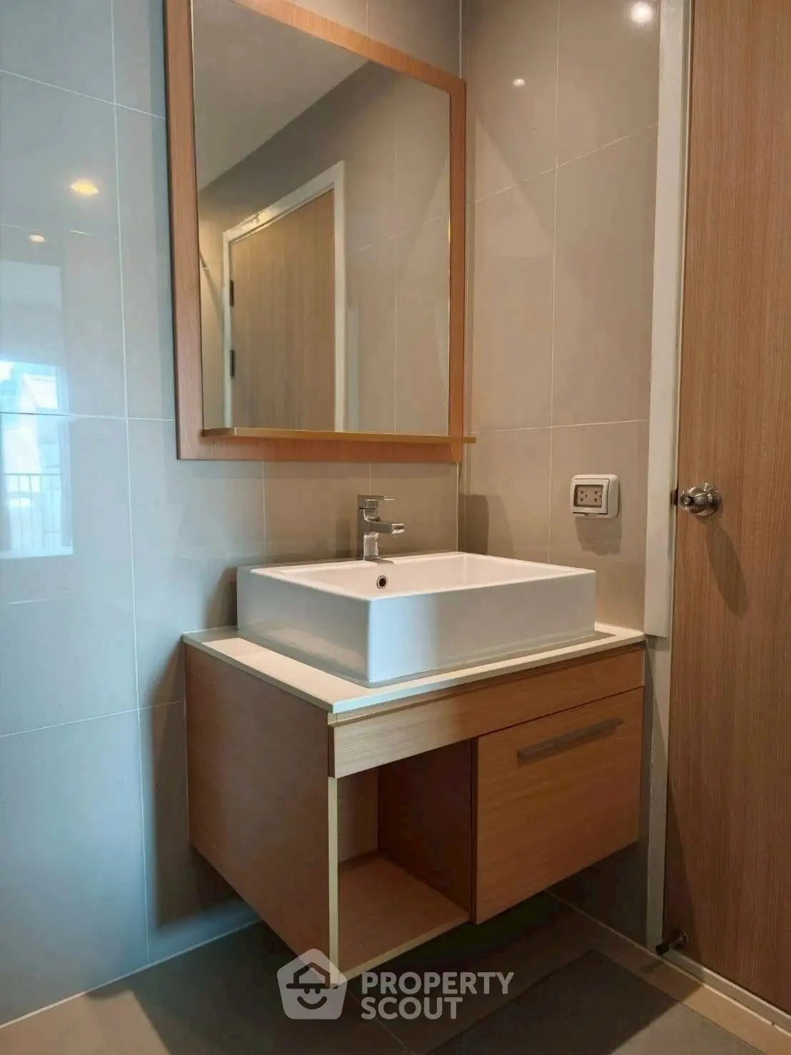 Modern bathroom with sleek vanity and stylish mirror in contemporary apartment.