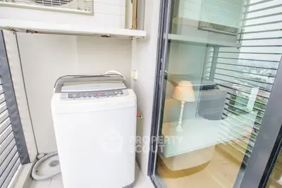 Compact balcony with washing machine and city view, perfect for urban living.