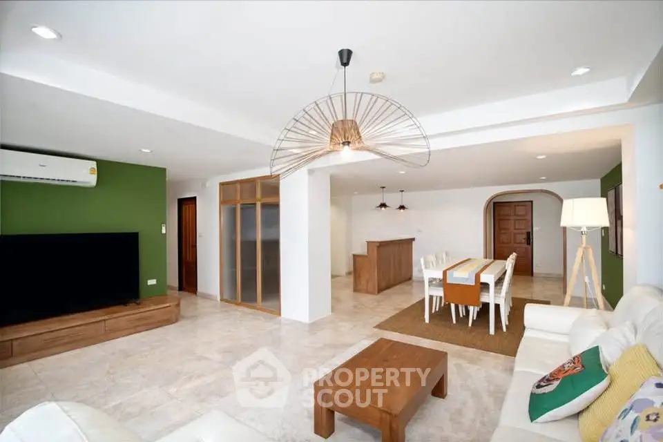 Spacious modern living room with dining area, featuring stylish decor and ample natural light.