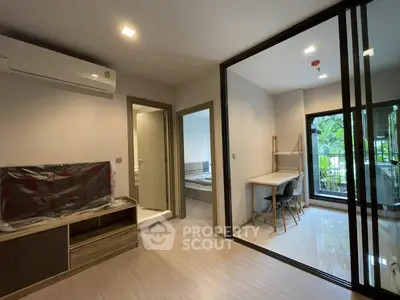 Modern apartment interior with study area and bedroom, featuring sleek design and natural light.
