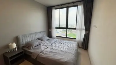 Cozy bedroom with large window offering a stunning city view, featuring a comfortable bed and modern decor.