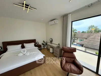 Modern bedroom with stylish decor and large window offering a scenic view.