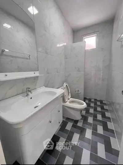 Modern bathroom with sleek fixtures and stylish tile flooring in a contemporary home.