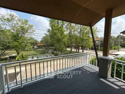 Spacious balcony with scenic view of lush greenery and quiet neighborhood.