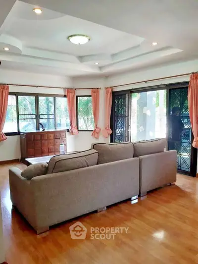 Spacious living room with large windows and cozy sofa, perfect for relaxation and entertaining.