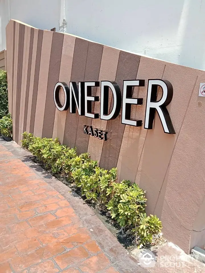 Modern building entrance with stylish signage and landscaped walkway