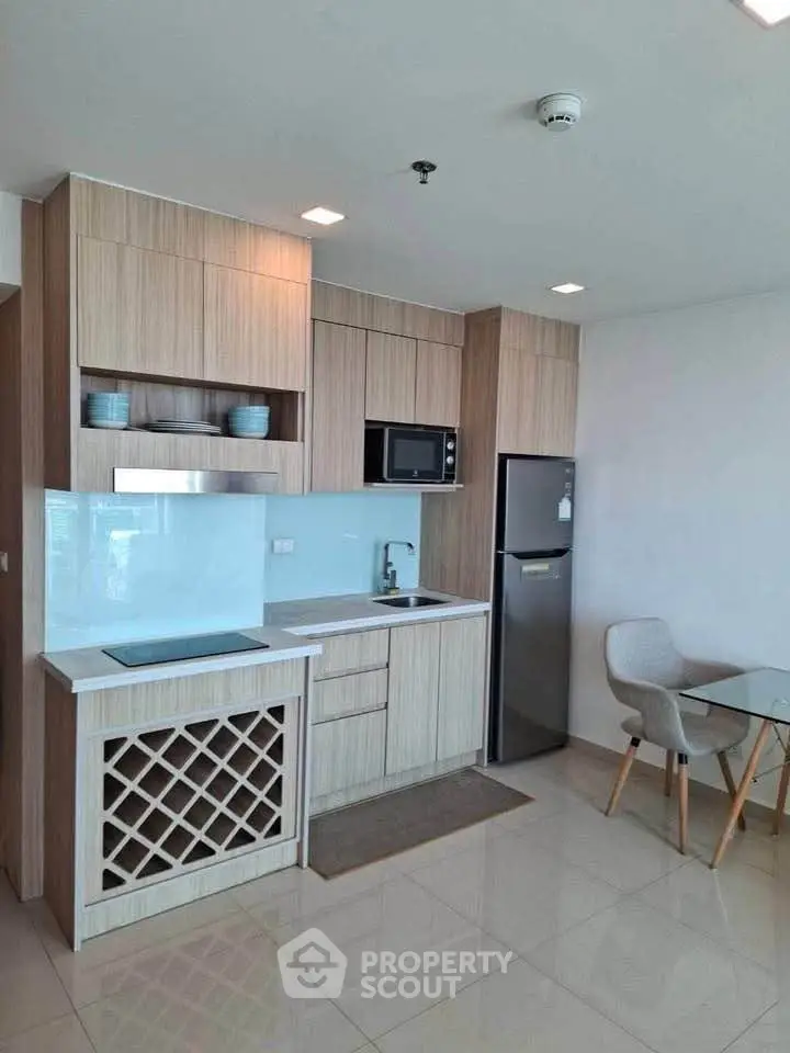 Modern kitchen with sleek cabinetry and dining area in a stylish apartment.