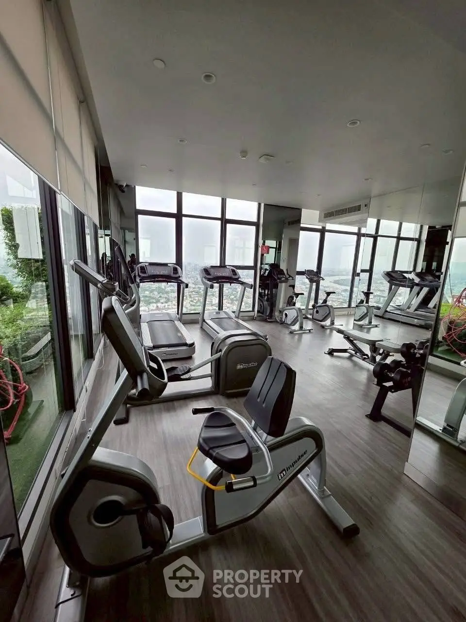 Modern gym with panoramic city views and state-of-the-art fitness equipment.