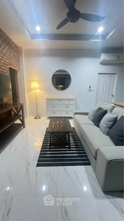 Modern living room with stylish decor, featuring a cozy sofa, sleek coffee table, and ambient lighting.