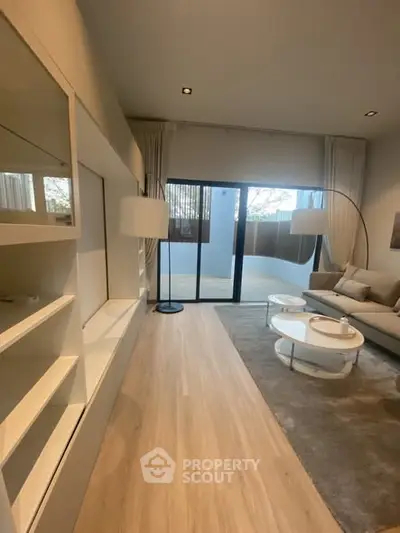 Modern living room with elegant decor and large sliding glass doors leading to a spacious balcony.