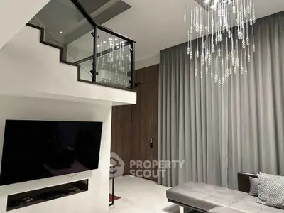 Modern living room with elegant chandelier and sleek staircase design