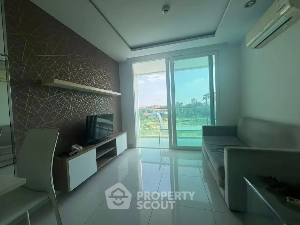 Modern living room with sleek design and large glass doors leading to a scenic balcony view.