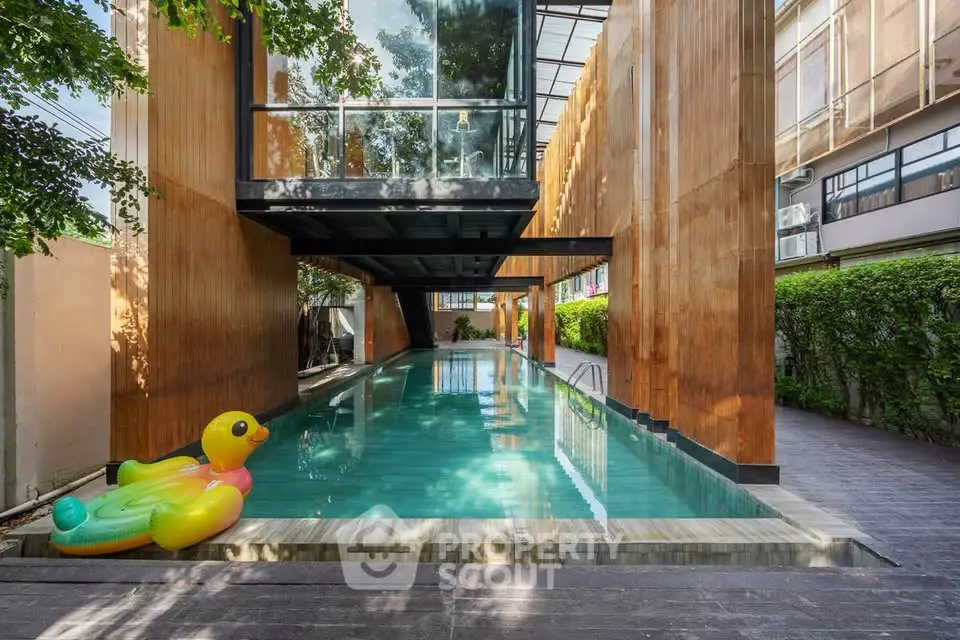 Luxurious modern pool area with unique architecture and inflatable duck float, perfect for relaxation.