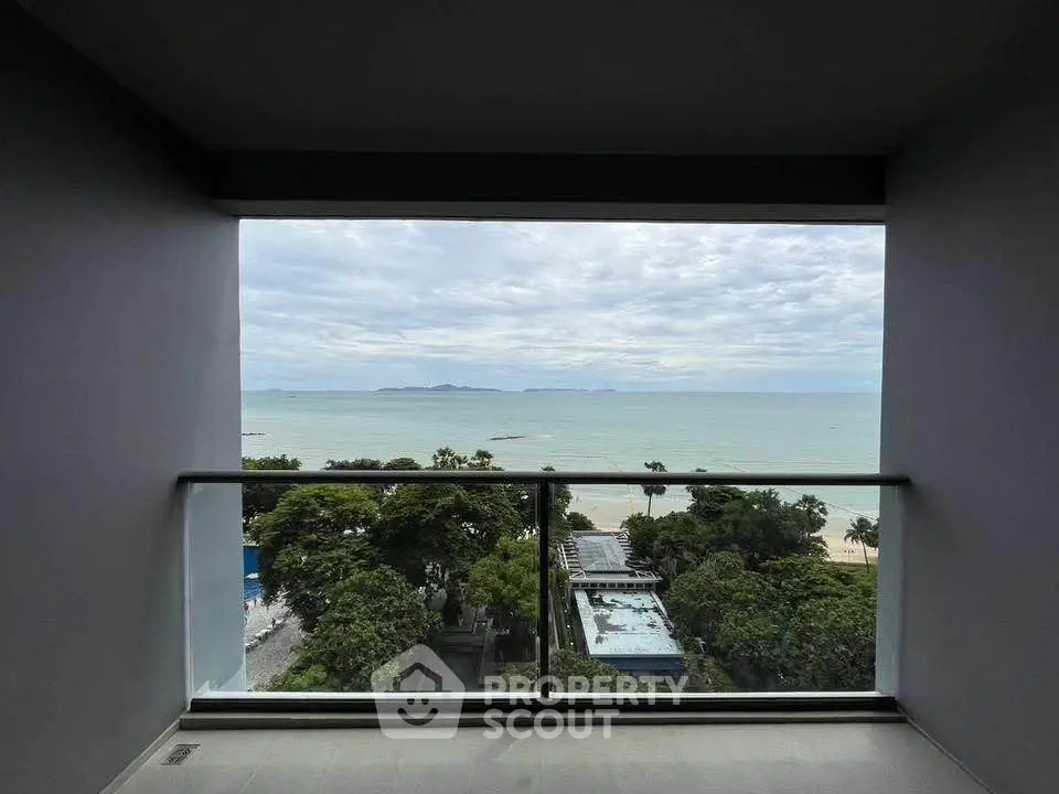 Stunning ocean view from modern balcony with glass railing, perfect for relaxation.