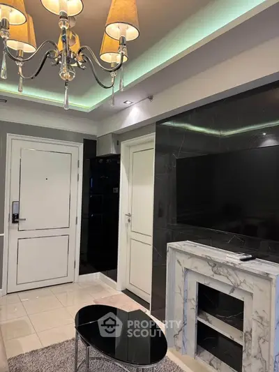 Elegant living room with modern chandelier and marble fireplace, perfect for cozy evenings.