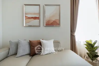 Elegant living room with modern decor, featuring a cozy beige sofa, stylish cushions, and framed artwork.