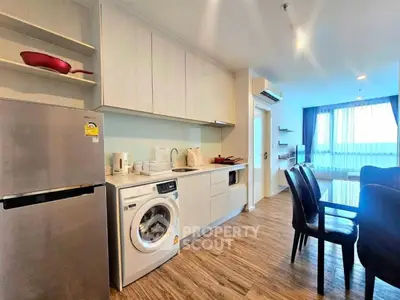 Modern kitchen with washing machine and dining area in open layout apartment