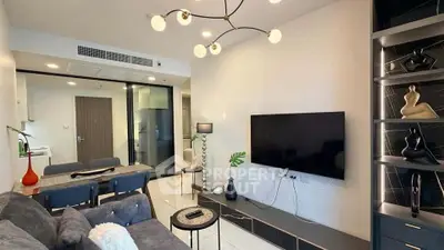 Modern living room with stylish decor, large TV, and elegant lighting in a contemporary apartment.