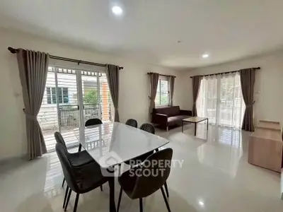 Spacious living room with modern dining area and large windows for natural light.