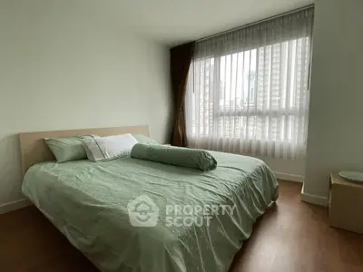 Spacious bedroom with large window and modern decor in urban apartment
