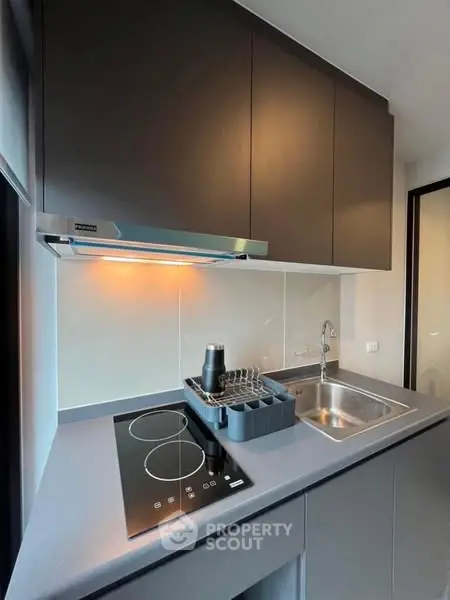 Modern compact kitchen with electric stove and sleek cabinetry