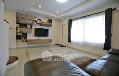 Spacious modern living room with sleek leather sofa and stylish wall-mounted TV unit.