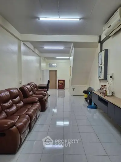 Spacious living room with leather sofas and modern air conditioning