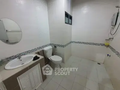 Spacious bathroom with modern fixtures and tiled walls