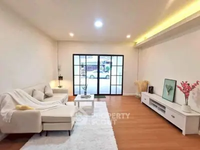 Spacious living room with modern decor and large glass doors leading outside.