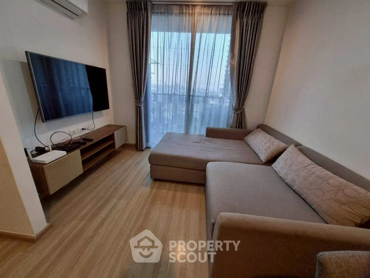 Cozy living room with modern sofa and large TV, perfect for relaxation.