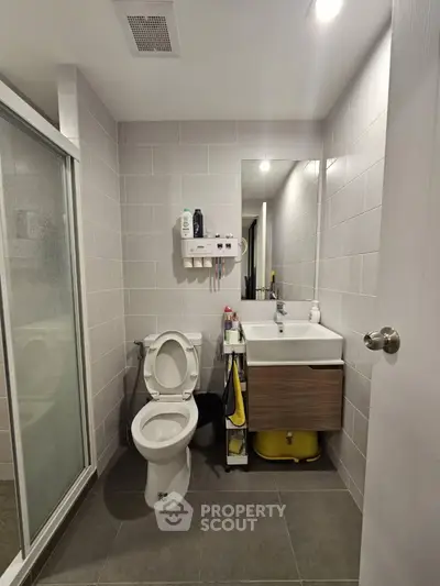 Modern bathroom with sleek tiles, shower, and stylish vanity unit