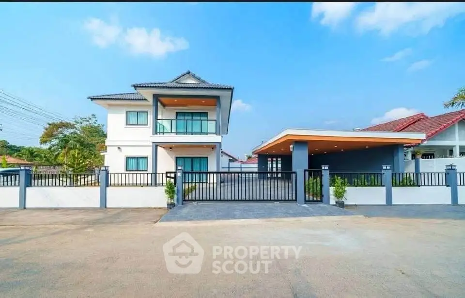 Modern two-story house with spacious driveway and sleek exterior design under a clear blue sky.