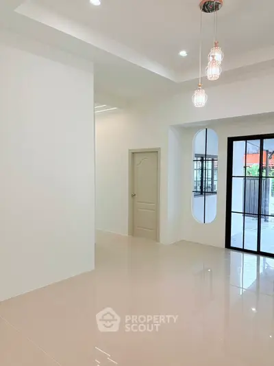 Modern interior with sleek lighting and glossy tiled floors, featuring a stylish door and large windows.