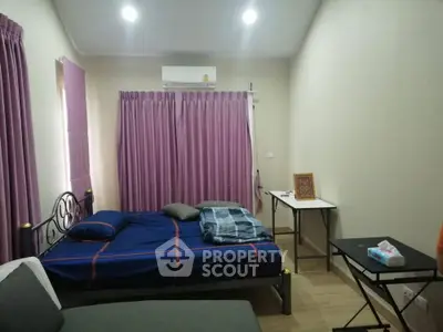Cozy bedroom with modern furnishings and air conditioning, perfect for comfortable living.