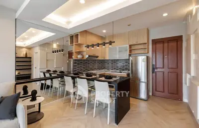 Modern open-layout kitchen with sleek design and dining area, featuring stylish lighting and contemporary decor.