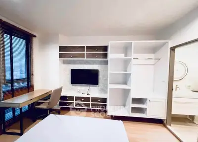 Modern bedroom with built-in storage and workspace, featuring a wall-mounted TV and large window.