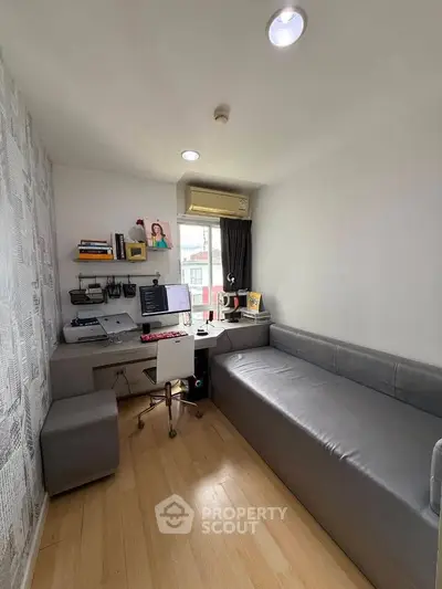 Modern study room with sleek desk, computer setup, and comfortable seating in a bright, compact space.