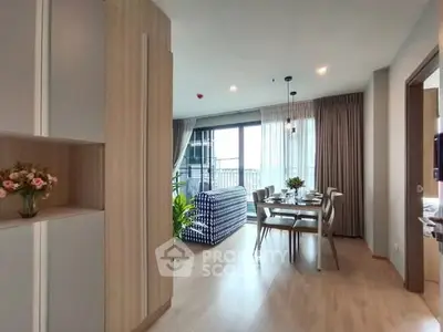 Modern open-plan living and dining area with large windows and stylish decor.