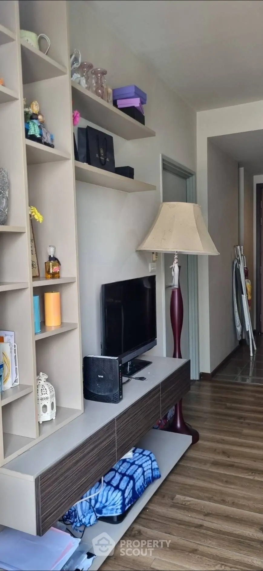 Stylish living room with modern shelving and elegant floor lamp, perfect for cozy urban living.