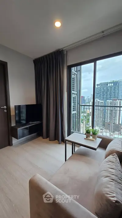Modern living room with city view, cozy sofa, and sleek TV setup in a high-rise apartment.