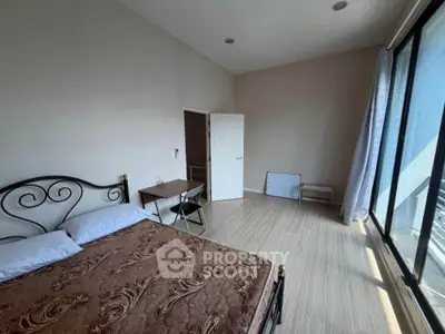 Spacious bedroom with large windows and elegant decor, perfect for natural light lovers.