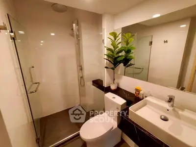 Modern bathroom with glass shower, sleek fixtures, and elegant decor in a contemporary home.