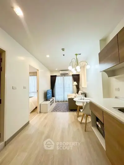 Modern open-plan living room and kitchen with stylish lighting and cozy decor.
