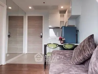 Modern apartment interior with cozy sofa and compact kitchen area.